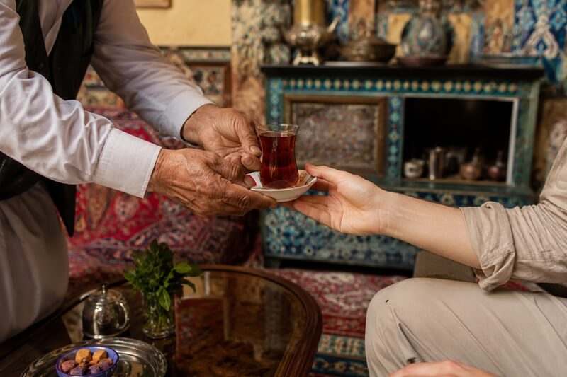 Compassimo-Local man offering tea to a tourist visiting Iran-Iran Cultural Etiquette