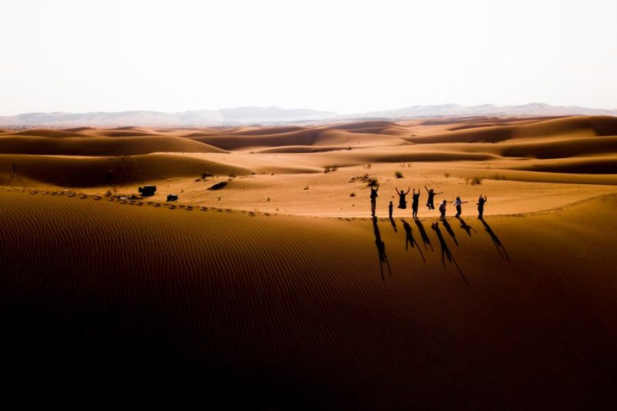 Compassimo-Aerial view of a group jumping in the Iranian desert at sunset